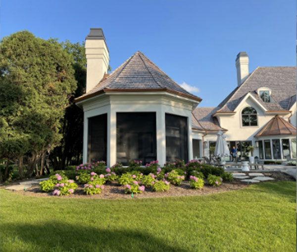 A covered outdoor living area at the rear of a home, with the screens retracted.
