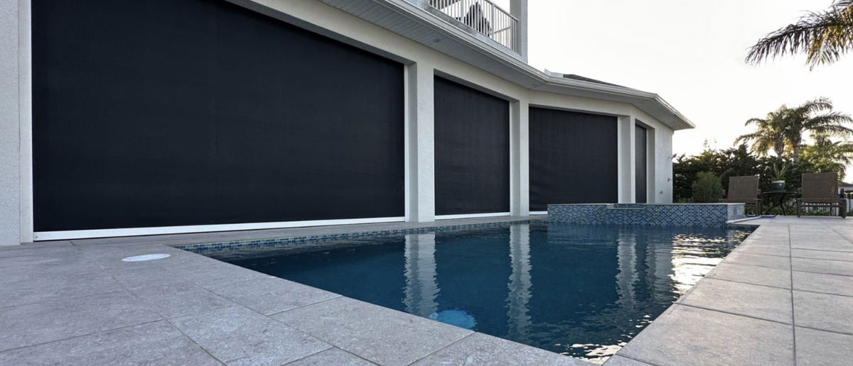 Motorized exterior screens lowered along a covered poolside patio.