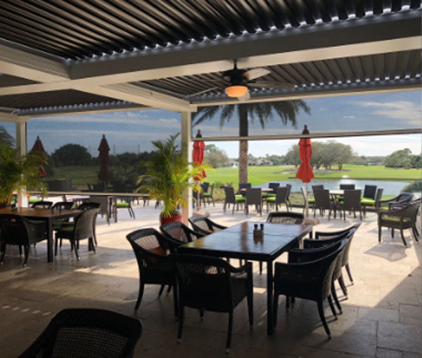Motorized exterior screens shading a covered patio dining area.