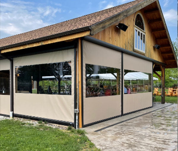 Clear vinyl weather screens enclosing an open-sided outdoor pavilion.